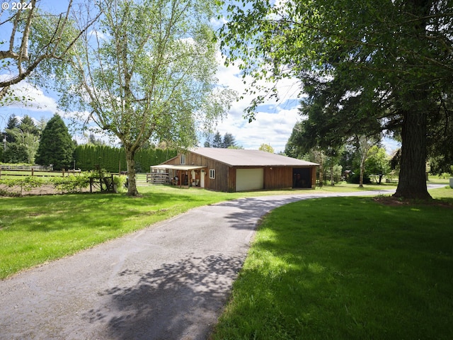 view of front of house featuring a garage, an outdoor structure, and a front lawn