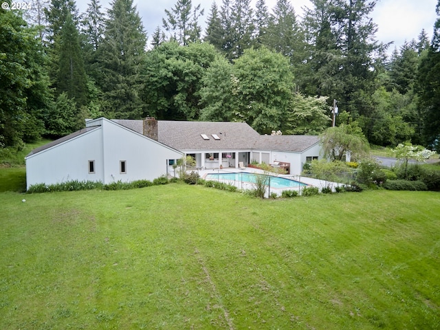 rear view of property featuring a patio area and a yard