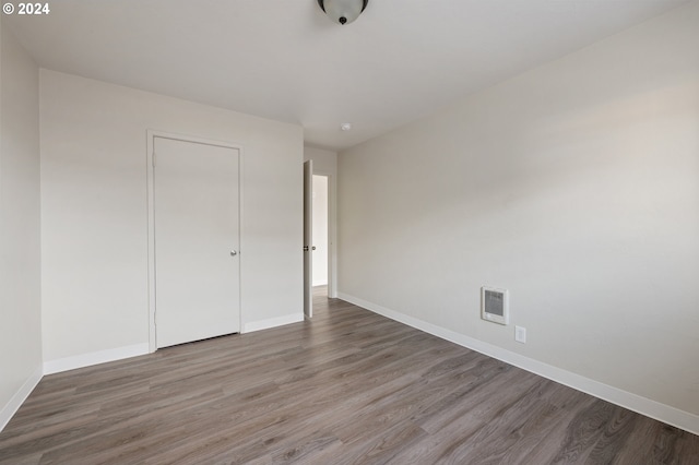 unfurnished bedroom featuring a closet and hardwood / wood-style flooring