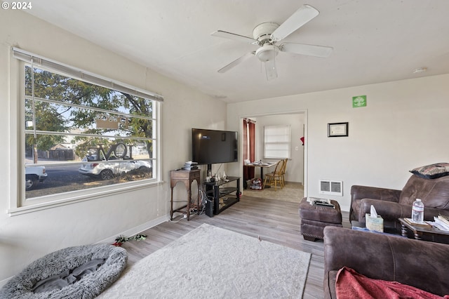 living room with light hardwood / wood-style floors and ceiling fan