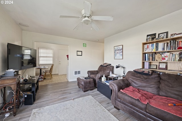 living room with light hardwood / wood-style flooring and ceiling fan