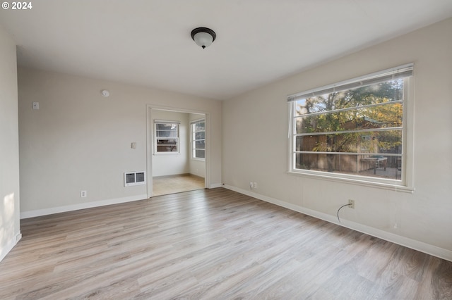 spare room featuring a wealth of natural light and light wood-type flooring