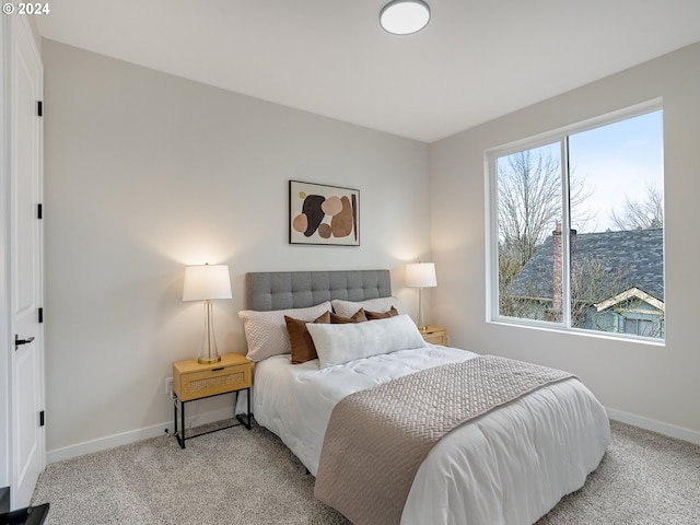 bedroom featuring light carpet and multiple windows