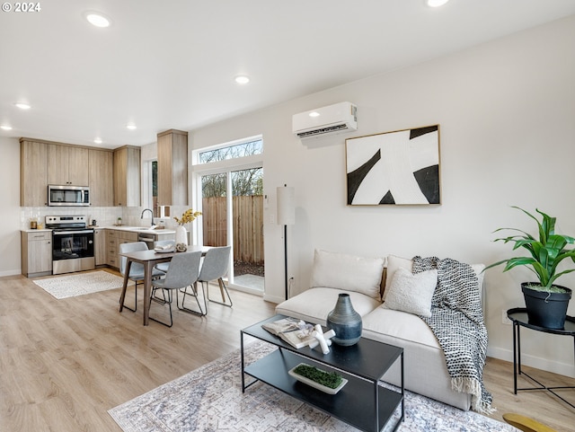 living room featuring a wall mounted AC, light hardwood / wood-style flooring, and sink