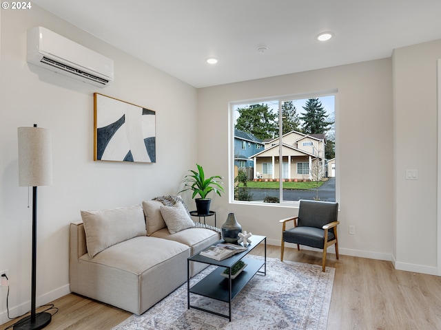 living room featuring a wall unit AC and light hardwood / wood-style floors