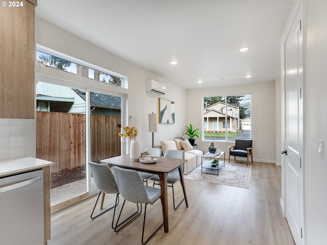 dining area with light wood-type flooring and a wall mounted AC