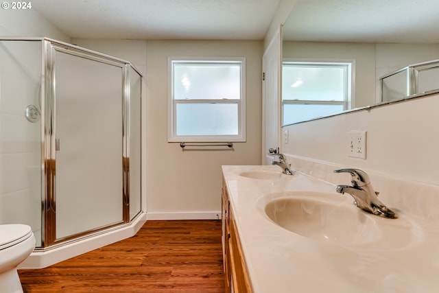 bathroom featuring wood finished floors, a stall shower, a sink, and toilet