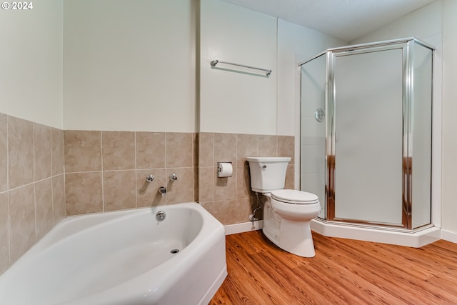 bathroom featuring a bath, wood finished floors, tile walls, and a shower stall