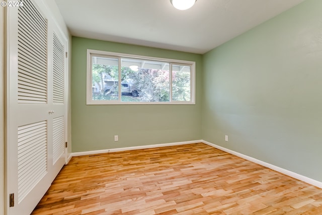 unfurnished bedroom featuring baseboards, a closet, and light wood-style floors