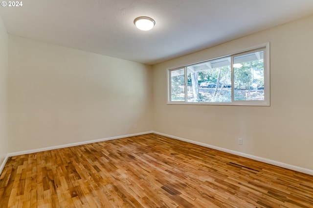 empty room with light wood-type flooring and baseboards