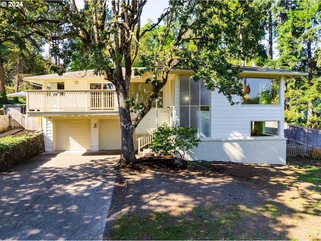 view of front of house with brick siding, concrete driveway, a garage, and fence