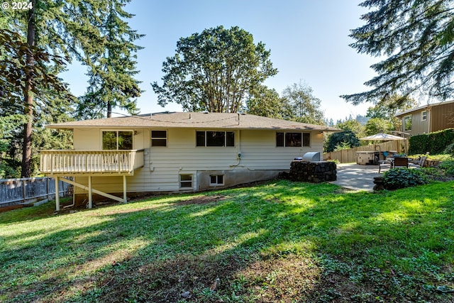 back of house featuring a lawn, a patio area, and fence