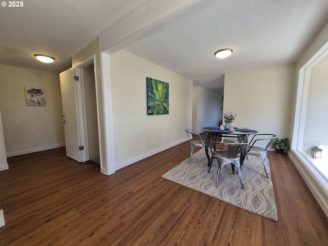 dining room with a textured ceiling, baseboards, and wood finished floors