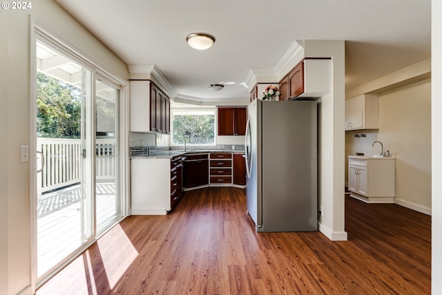 kitchen with a sink, baseboards, dark wood-type flooring, and freestanding refrigerator