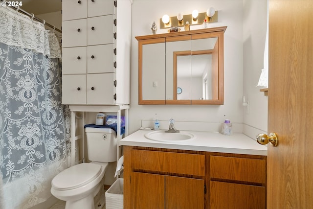 bathroom with curtained shower, vanity, and toilet