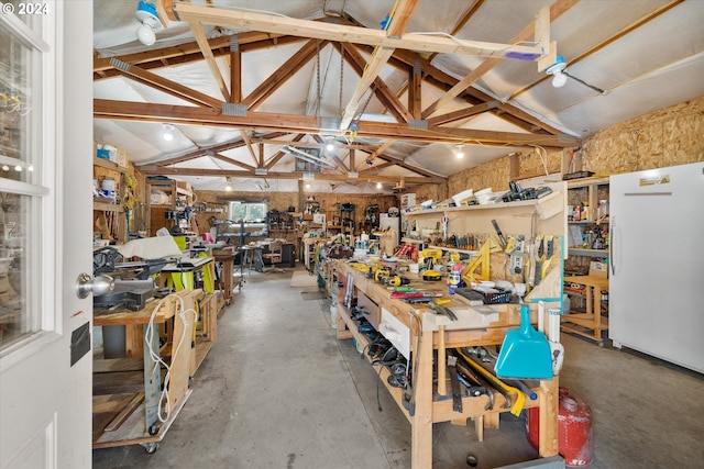 garage featuring a workshop area and white fridge