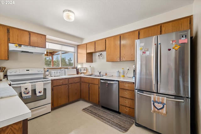 kitchen with a textured ceiling, sink, and appliances with stainless steel finishes