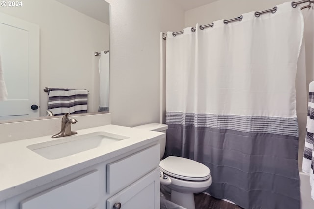 bathroom featuring toilet, vanity, and hardwood / wood-style flooring