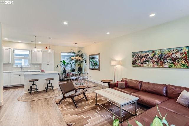 living room featuring sink and light hardwood / wood-style flooring