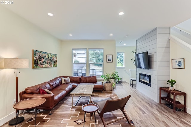 living room with light hardwood / wood-style flooring and a large fireplace