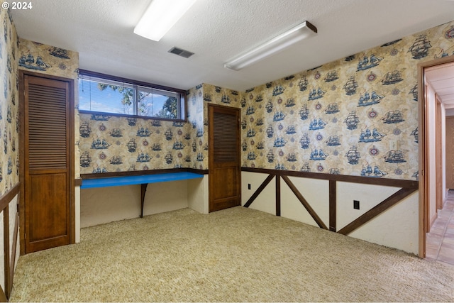 interior space featuring carpet floors and a textured ceiling