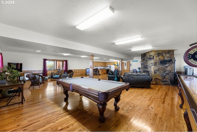 playroom featuring light wood-type flooring, pool table, and a textured ceiling