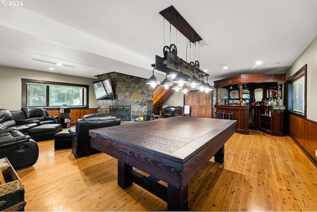 recreation room with billiards, a fireplace, light hardwood / wood-style flooring, and bar