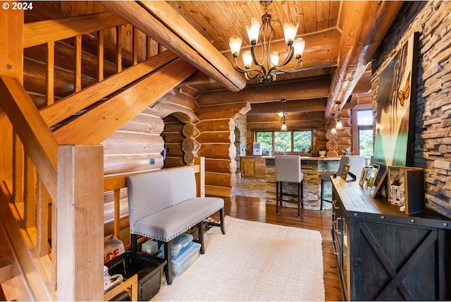 sitting room with beamed ceiling, an inviting chandelier, log walls, wooden ceiling, and dark hardwood / wood-style flooring