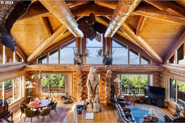 living room with rustic walls, high vaulted ceiling, and wooden ceiling