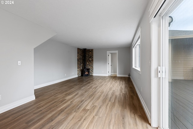 unfurnished living room with hardwood / wood-style floors and a wood stove