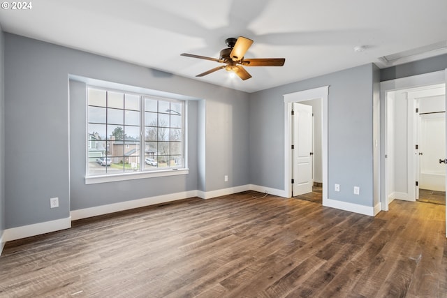 unfurnished bedroom with ensuite bathroom, dark hardwood / wood-style flooring, and ceiling fan