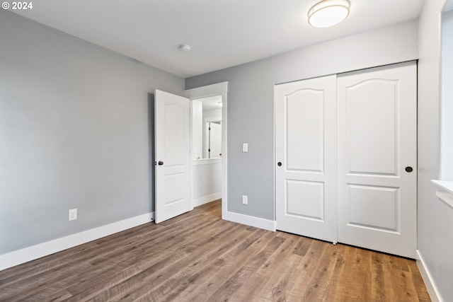 unfurnished bedroom with light hardwood / wood-style flooring and a closet