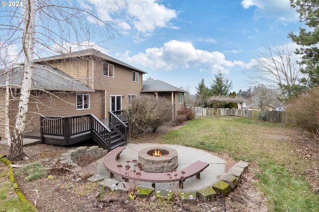 back of house with a wooden deck, a yard, a patio, and an outdoor fire pit