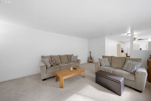 carpeted living room with ceiling fan