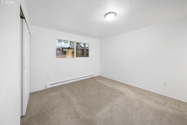 carpeted empty room with a textured ceiling and baseboard heating