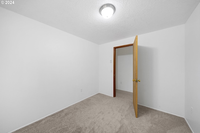 carpeted spare room featuring a textured ceiling