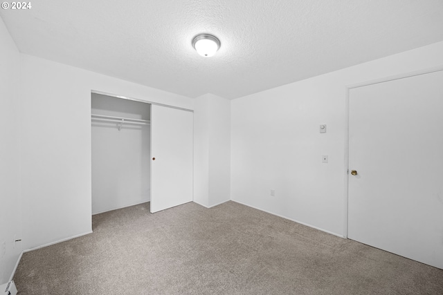 unfurnished bedroom with carpet, a closet, and a textured ceiling