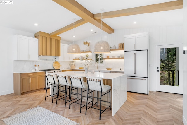 kitchen with light parquet flooring, vaulted ceiling with beams, a kitchen island with sink, a breakfast bar, and high quality appliances