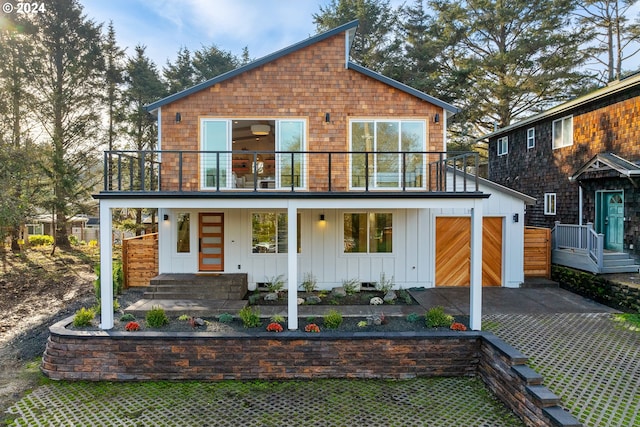 view of front of property featuring a balcony, a garage, and covered porch