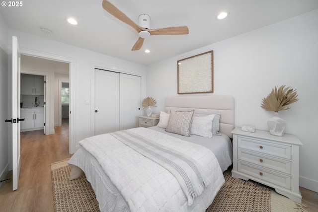 bedroom featuring ceiling fan, a closet, and light hardwood / wood-style flooring