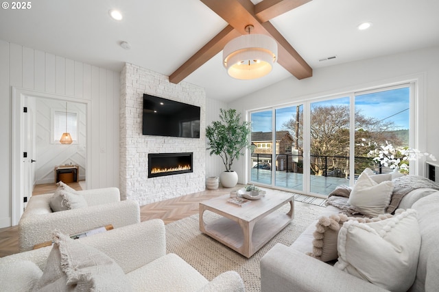 living room with a wealth of natural light, parquet floors, a stone fireplace, and lofted ceiling with beams