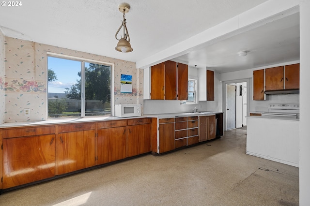 kitchen featuring sink, pendant lighting, and white appliances