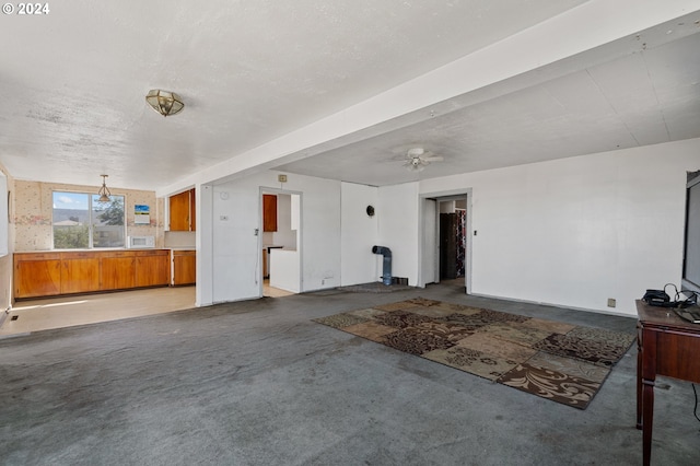 unfurnished living room featuring carpet and ceiling fan