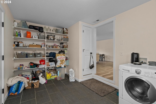 laundry room featuring a textured ceiling, washer / clothes dryer, and dark hardwood / wood-style flooring