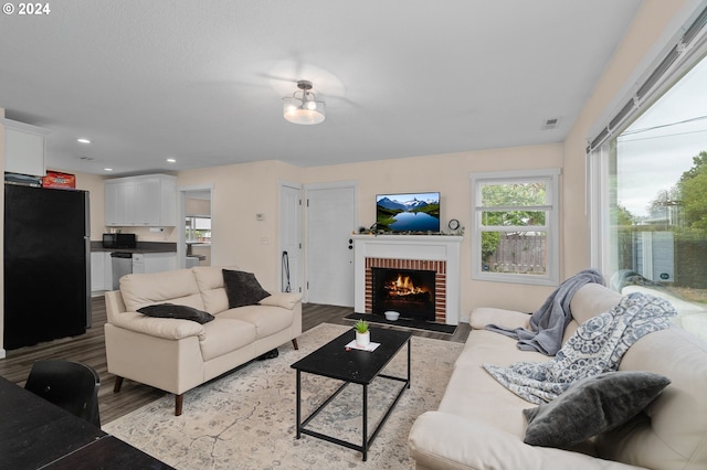 living room featuring light hardwood / wood-style flooring and a brick fireplace