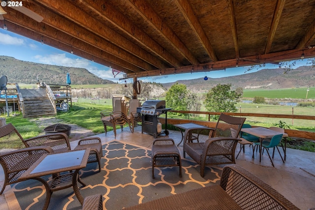 view of patio / terrace with area for grilling, a rural view, and a mountain view