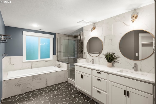 bathroom with a textured ceiling, vanity, independent shower and bath, and tile walls