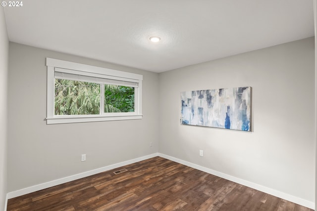 unfurnished room featuring dark hardwood / wood-style flooring and a textured ceiling