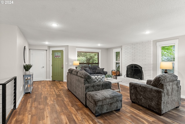 living room featuring a textured ceiling, a brick fireplace, beverage cooler, and dark hardwood / wood-style floors