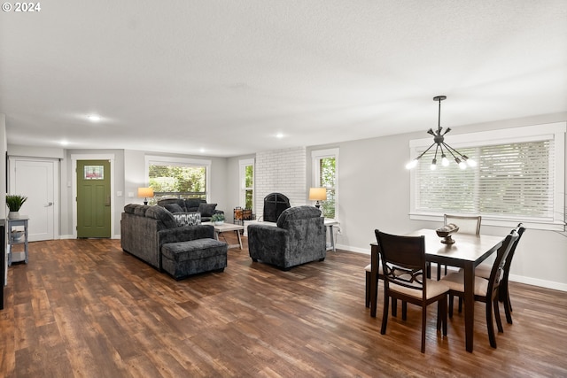 dining area with dark hardwood / wood-style flooring, a chandelier, and a textured ceiling